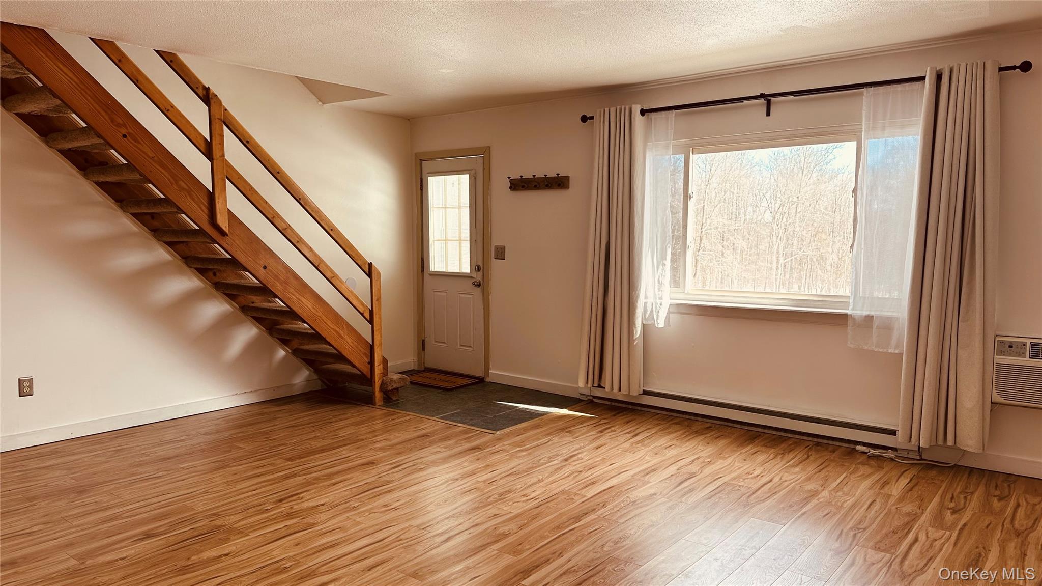 881 Albany Post Road, Unit 17 New Paltz, NY 12561 - Photo 9 of 15 a view of an empty room with wooden floor and a window
