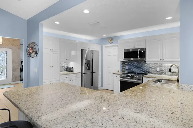 a bathroom with granite countertop a sink and a mirror