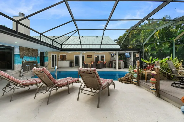 an aerial view of a house with a garden and lake view in back