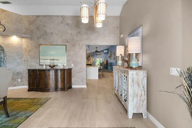 a living room with furniture a large window and wooden floor