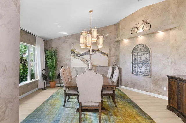 a kitchen with stainless steel appliances kitchen island granite countertop a table chairs in it and wooden floors