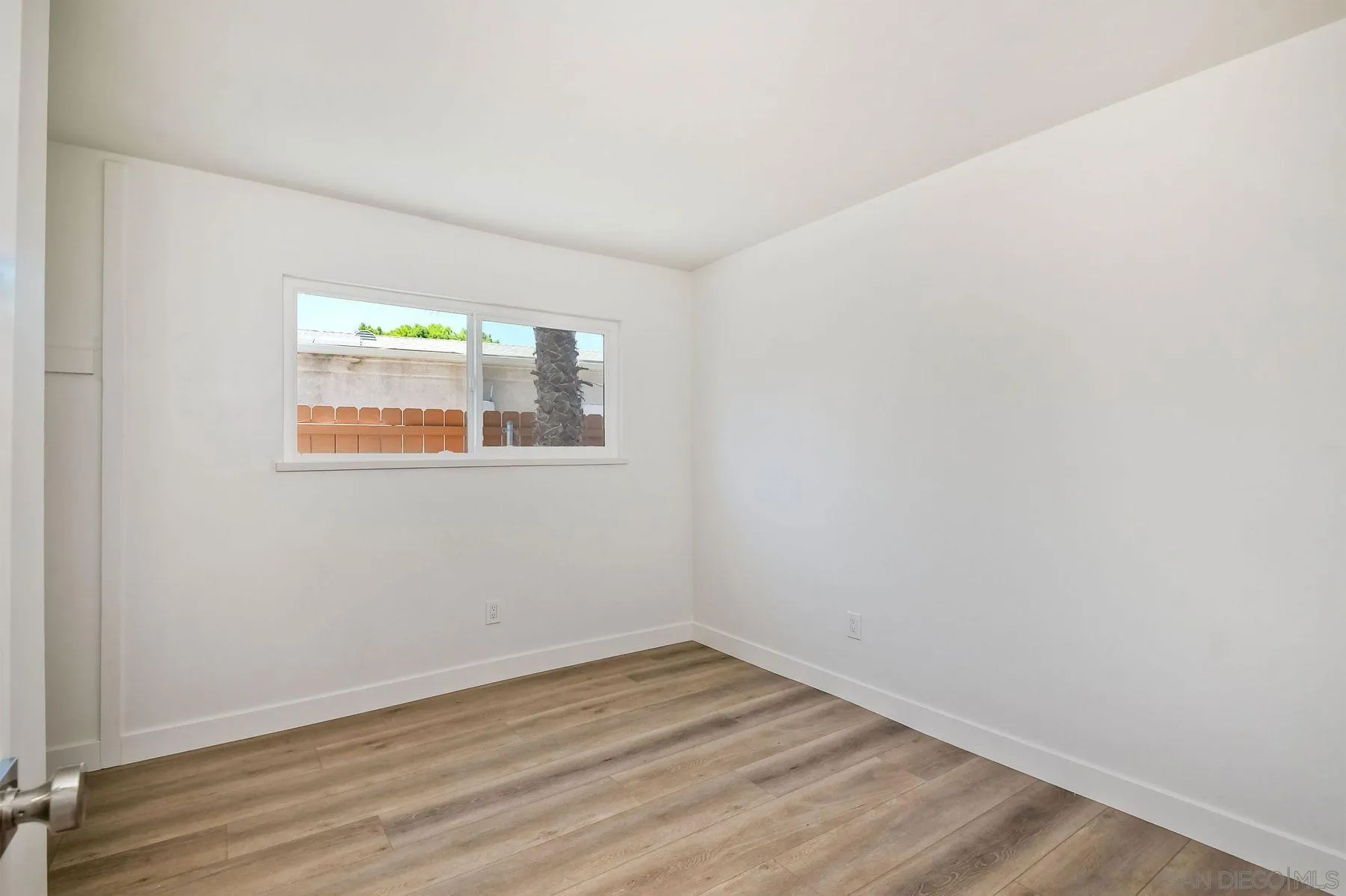 9045 Inverness Road Santee, CA 92071 - Photo 16 of 28 a view of an empty room with wooden floor and a window