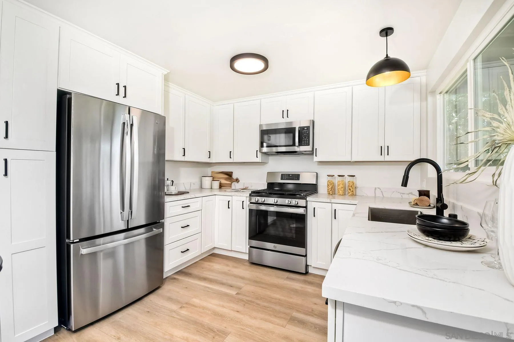 9045 Inverness Road Santee, CA 92071 - Photo 10 of 28 a kitchen with white cabinets and stainless steel appliances
