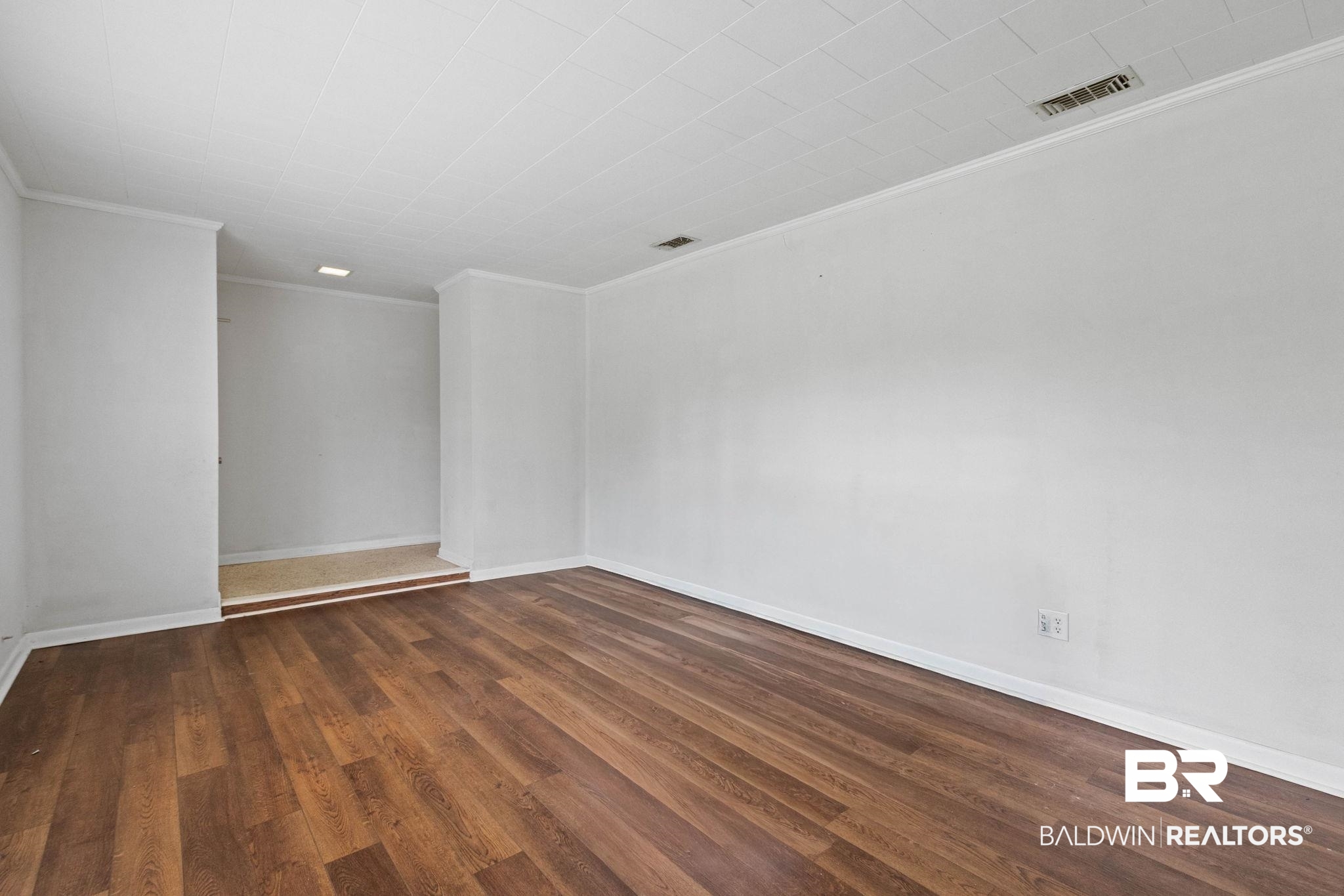 384 Old Bratt Road Atmore, AL 36502 - Photo 32 of 64 Spacious interior room featuring wood-finish flooring, white walls, white trim, and a white ceiling with a textured finish