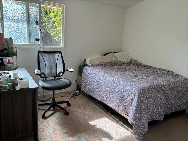 a bed sitting in a bedroom next to a window