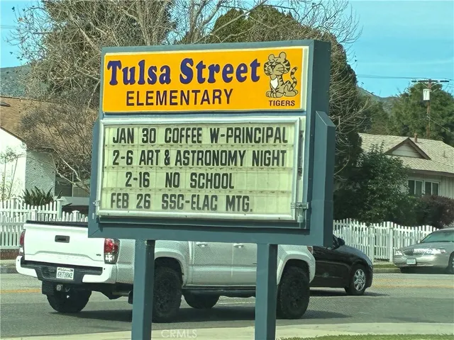 a view of a porch with chairs and potted plants