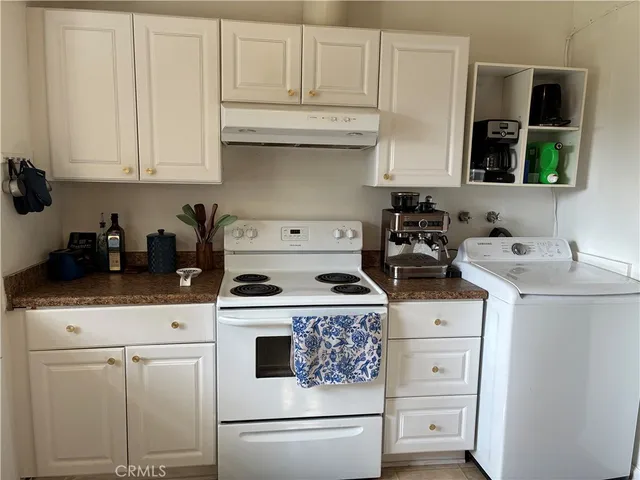 a kitchen with white cabinets and white appliances