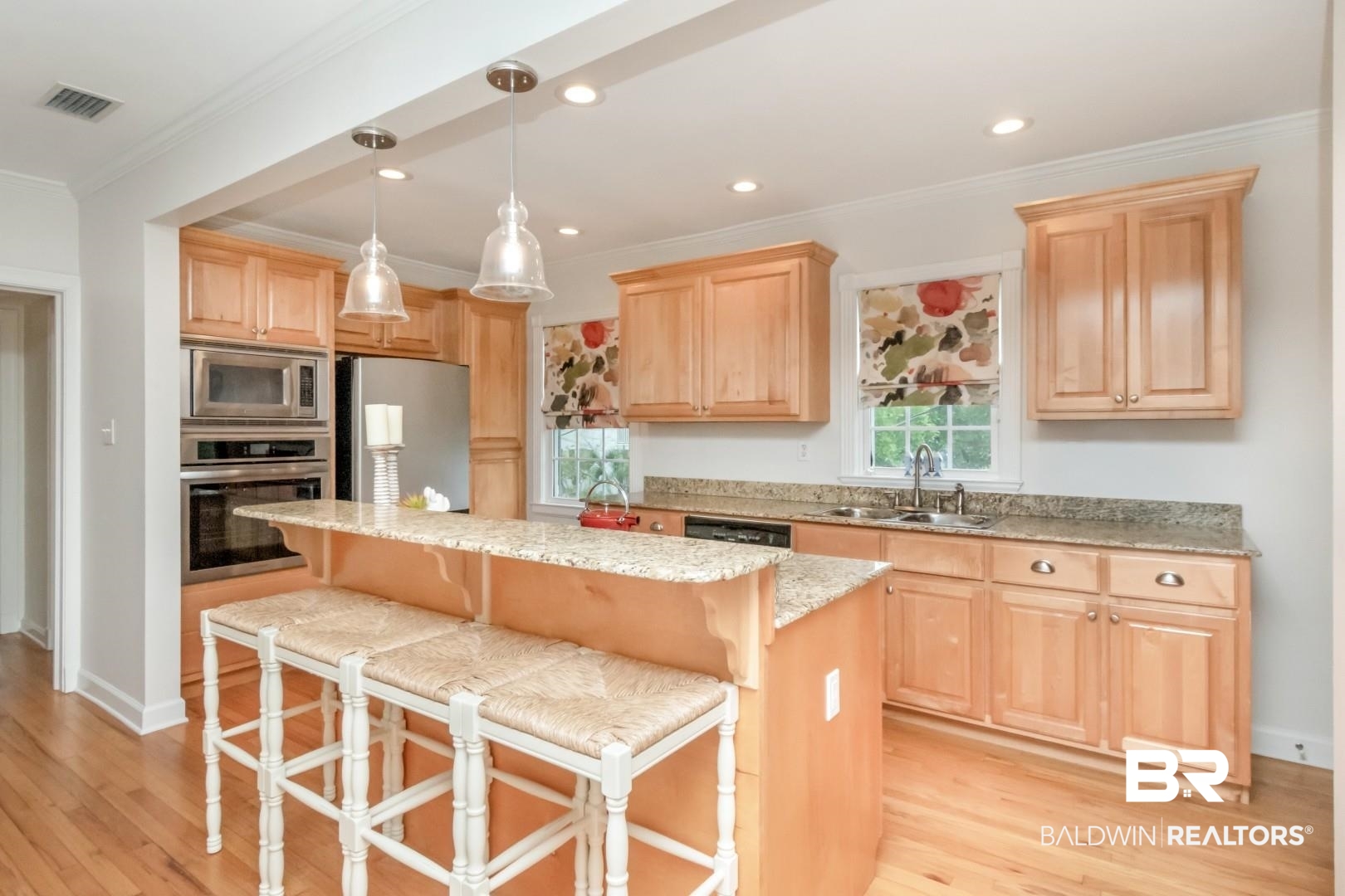 214 Upham Street, Unit 3D Mobile, AL 36607 - Photo 9 of 34 Kitchen with light stone countertops, stainless steel appliances, light wood finish cabinets, a breakfast bar, and crown molding