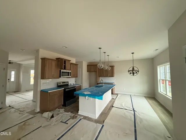 a large kitchen with kitchen island a sink stainless steel appliances and cabinets