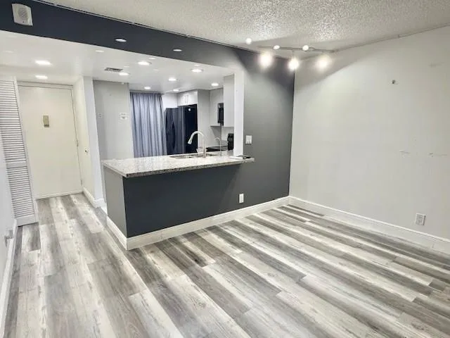 a view of kitchen with kitchen island sink and refrigerator