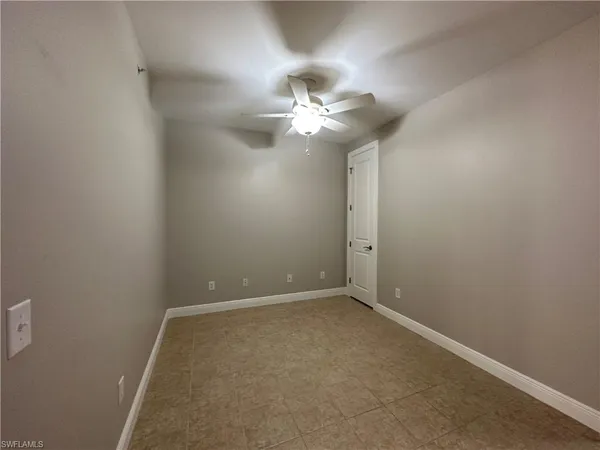 en empty room with ceiling fan and window