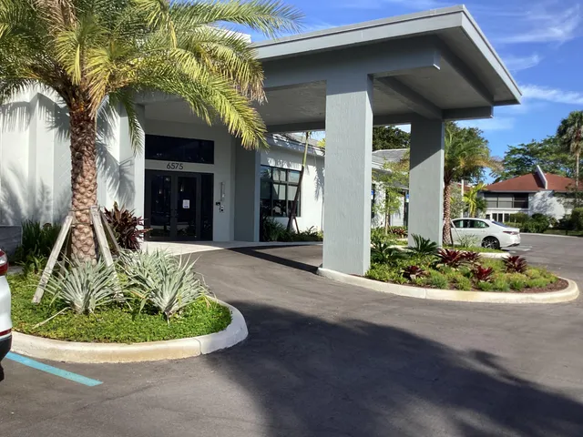 a view of a house with a yard and sitting area