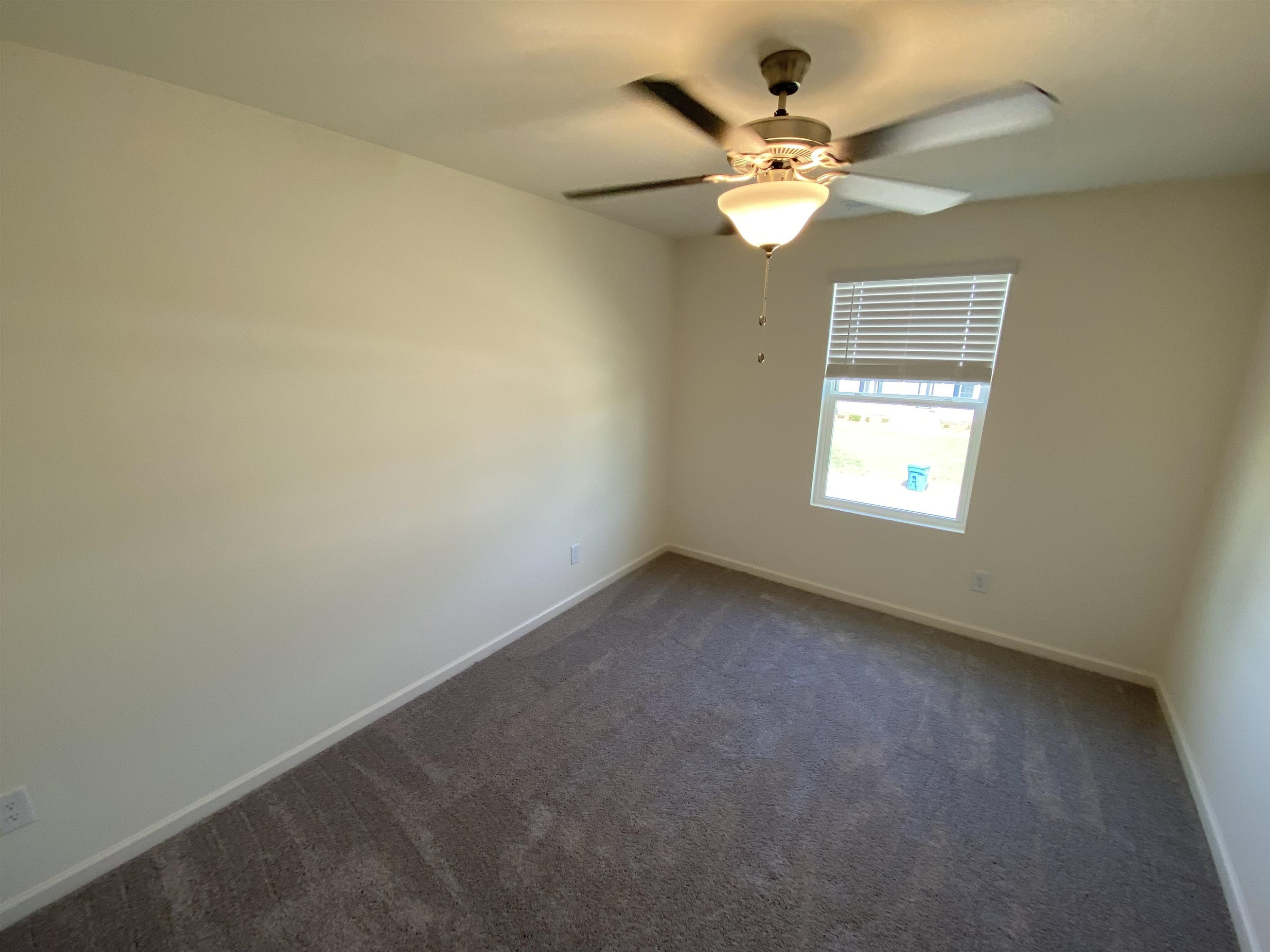 3403 Walker Drive Wilson, NC 27893 - Photo 14 of 19 an empty room with windows and chandelier fan