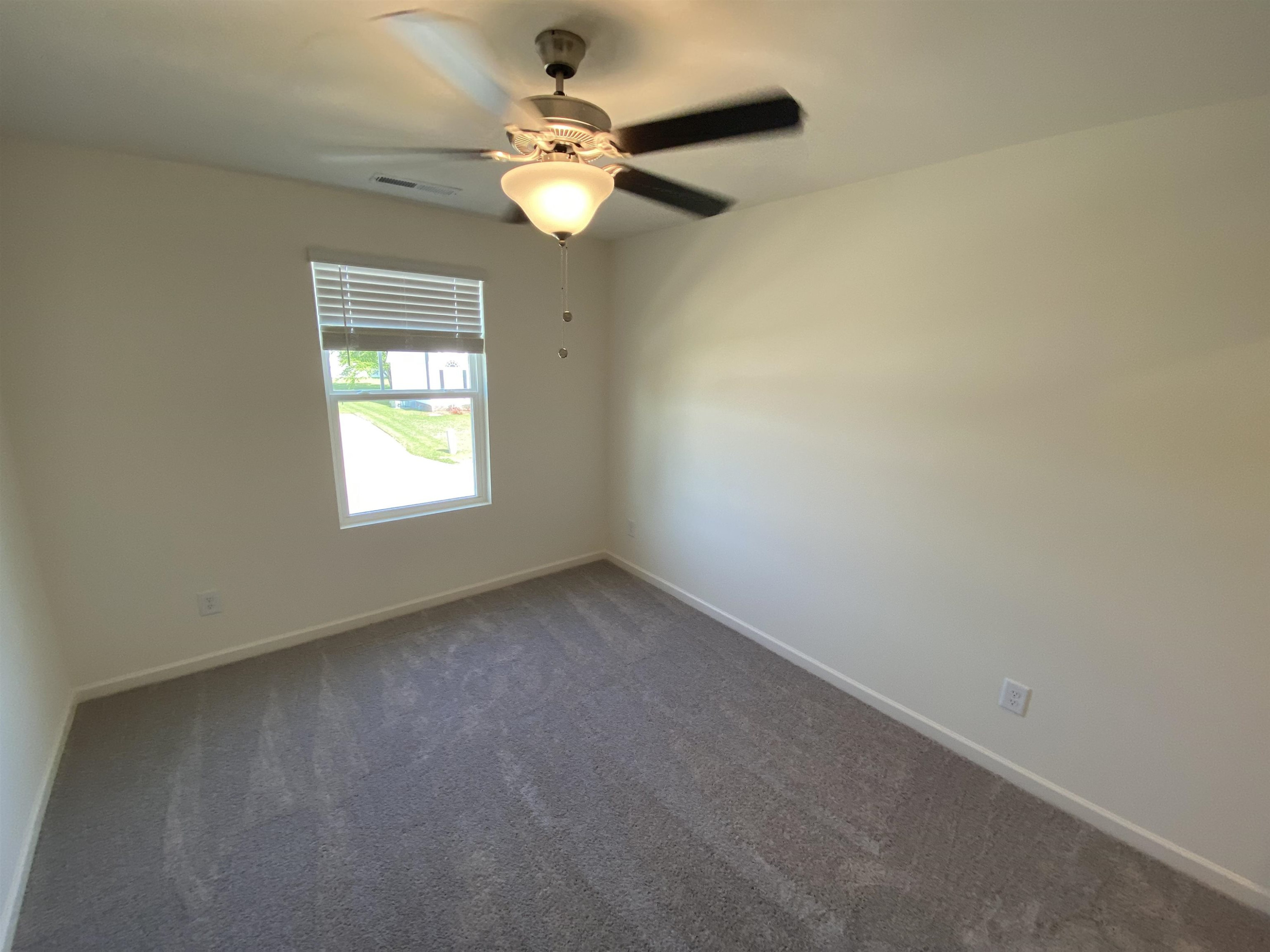 3403 Walker Drive Wilson, NC 27893 - Photo 16 of 19 an empty room with a chandelier fan and a window