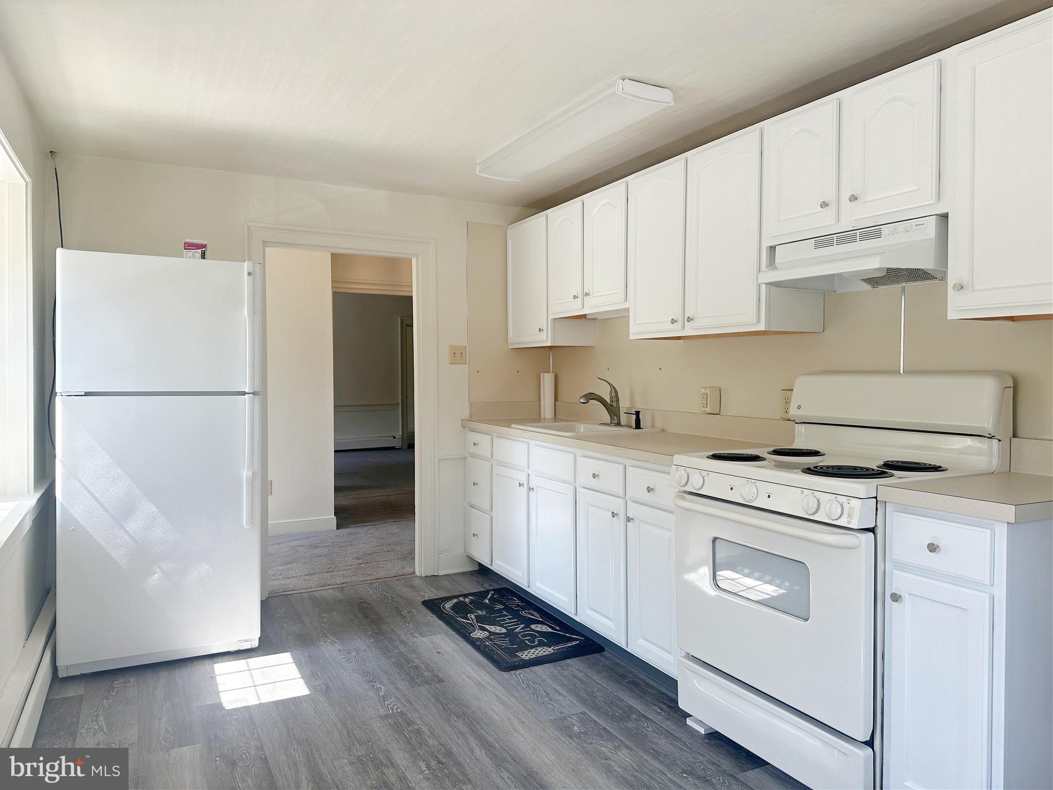 3198 Main Street Green Lane, PA 18054 - Photo 10 of 18 a kitchen with cabinets appliances wooden floor and a window