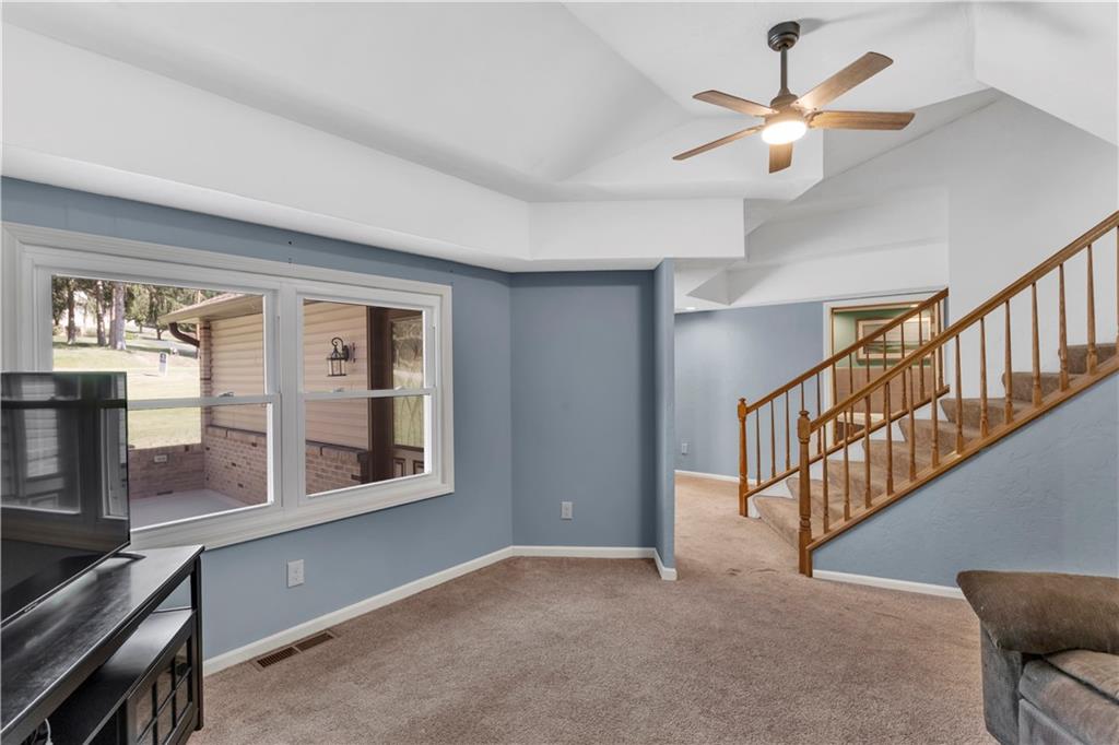 2171 Robbins Station Road Irwin, PA 15642 - Photo 24 of 50 Living Room features a spacious layout with abundant natural light, a hardwood staircase, and a neutral color palette throughout.