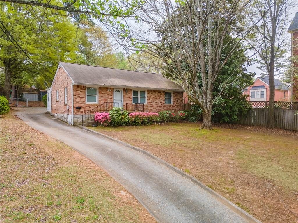 a front view of house with yard and trees around