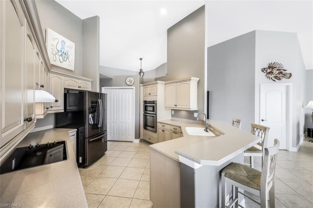21641 Helmsdale Run Estero, FL 33928 - Photo 21 of 35 a large kitchen with a refrigerator a stove a sink and dishwasher