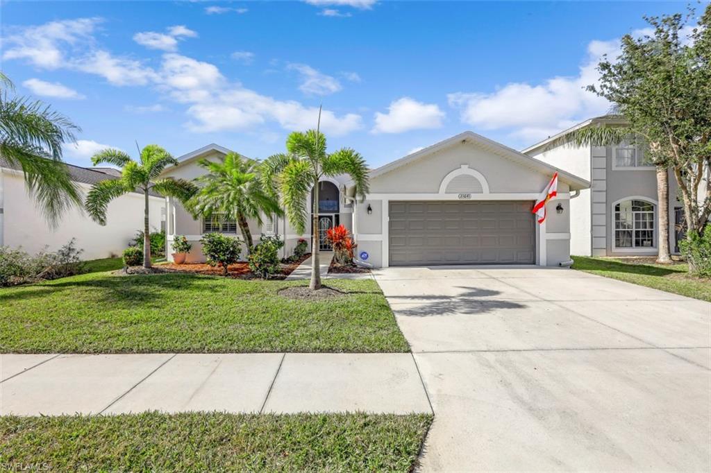 21641 Helmsdale Run Estero, FL 33928 - Photo 3 of 35 a front view of a house with a yard and palm trees