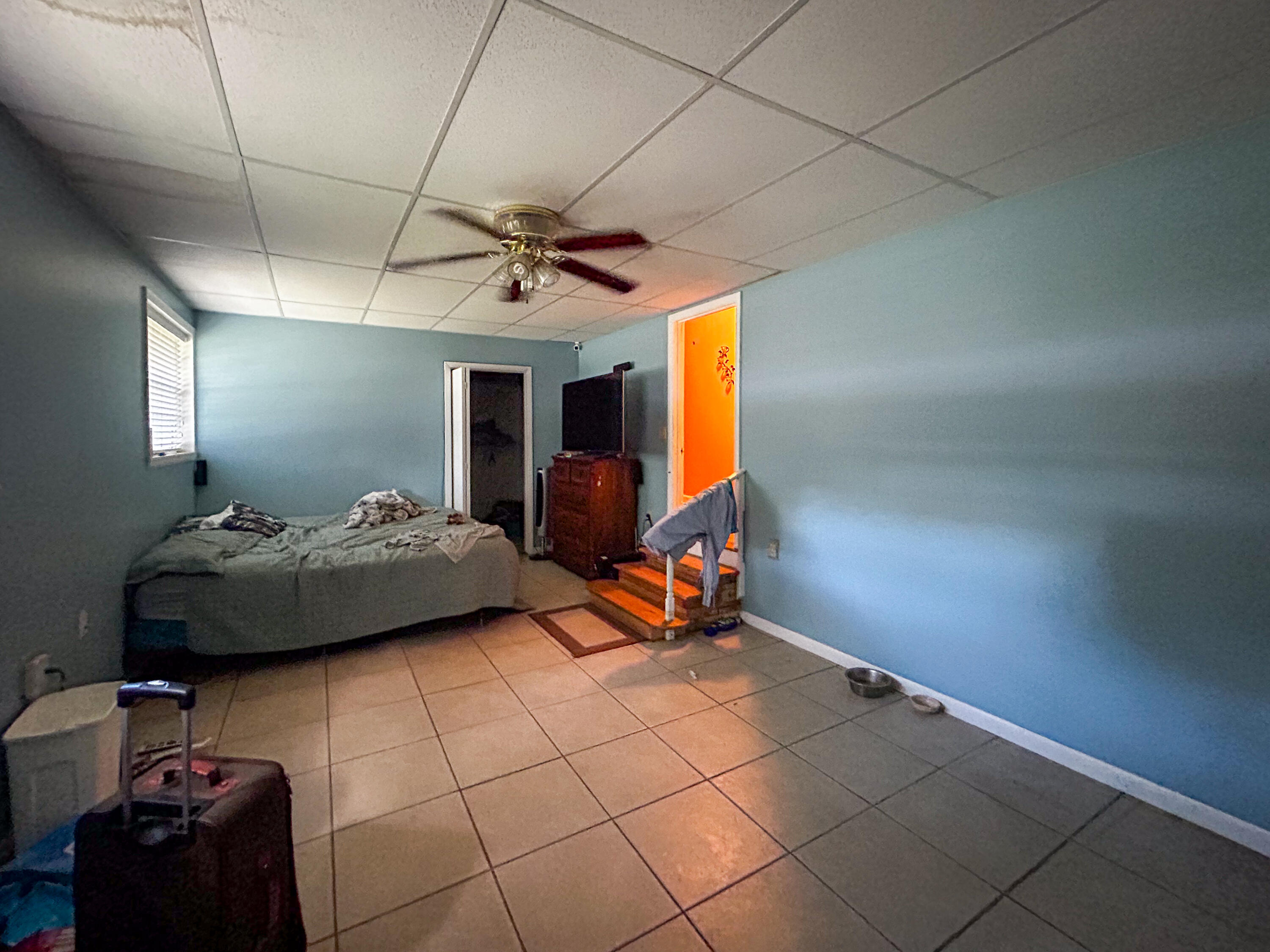 2446 Southeast Carroll Street Stuart, FL 34997 - Photo 23 of 37 a bedroom with a bed and a chandelier