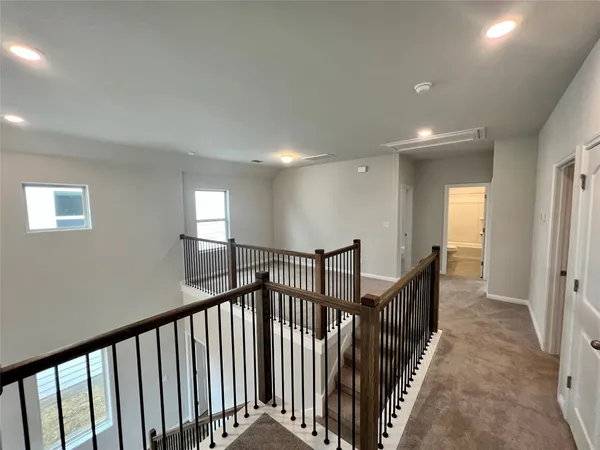 a view of a hallway with wooden floor and stairs