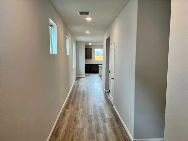a view of a hallway with wooden floor and staircase