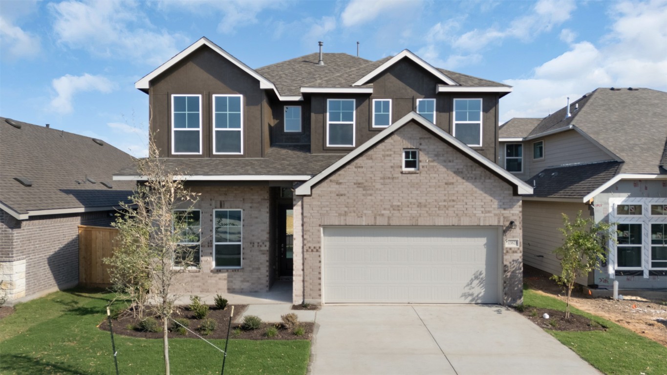a front view of a house with a yard and garage