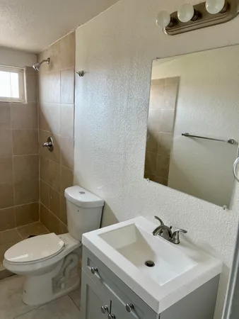 a bathroom with a sink mirror toilet and shower