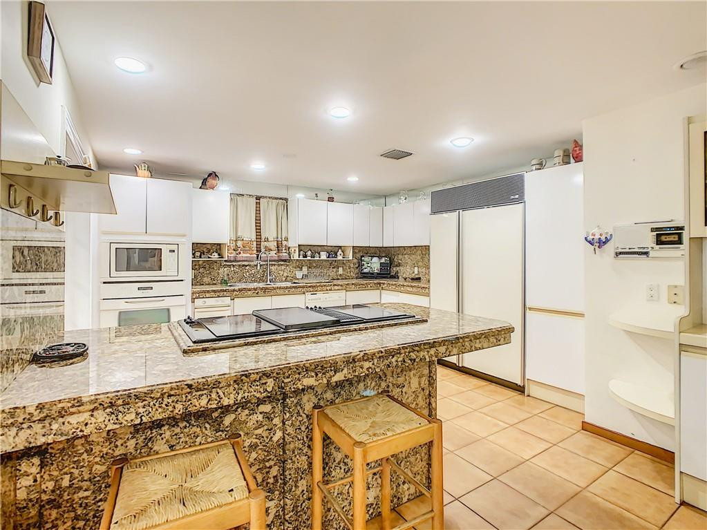 1234 Funston Street Hollywood, FL 33019 - Photo 8 of 23 a large kitchen with cabinets and a wooden floor