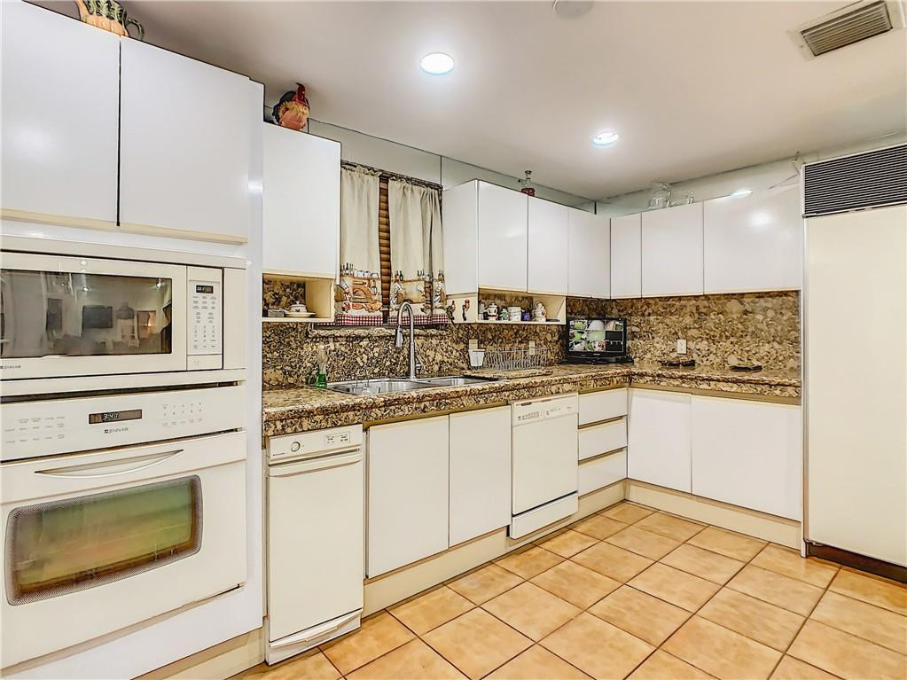 1234 Funston Street Hollywood, FL 33019 - Photo 9 of 23 a kitchen with granite countertop white cabinets and white appliances