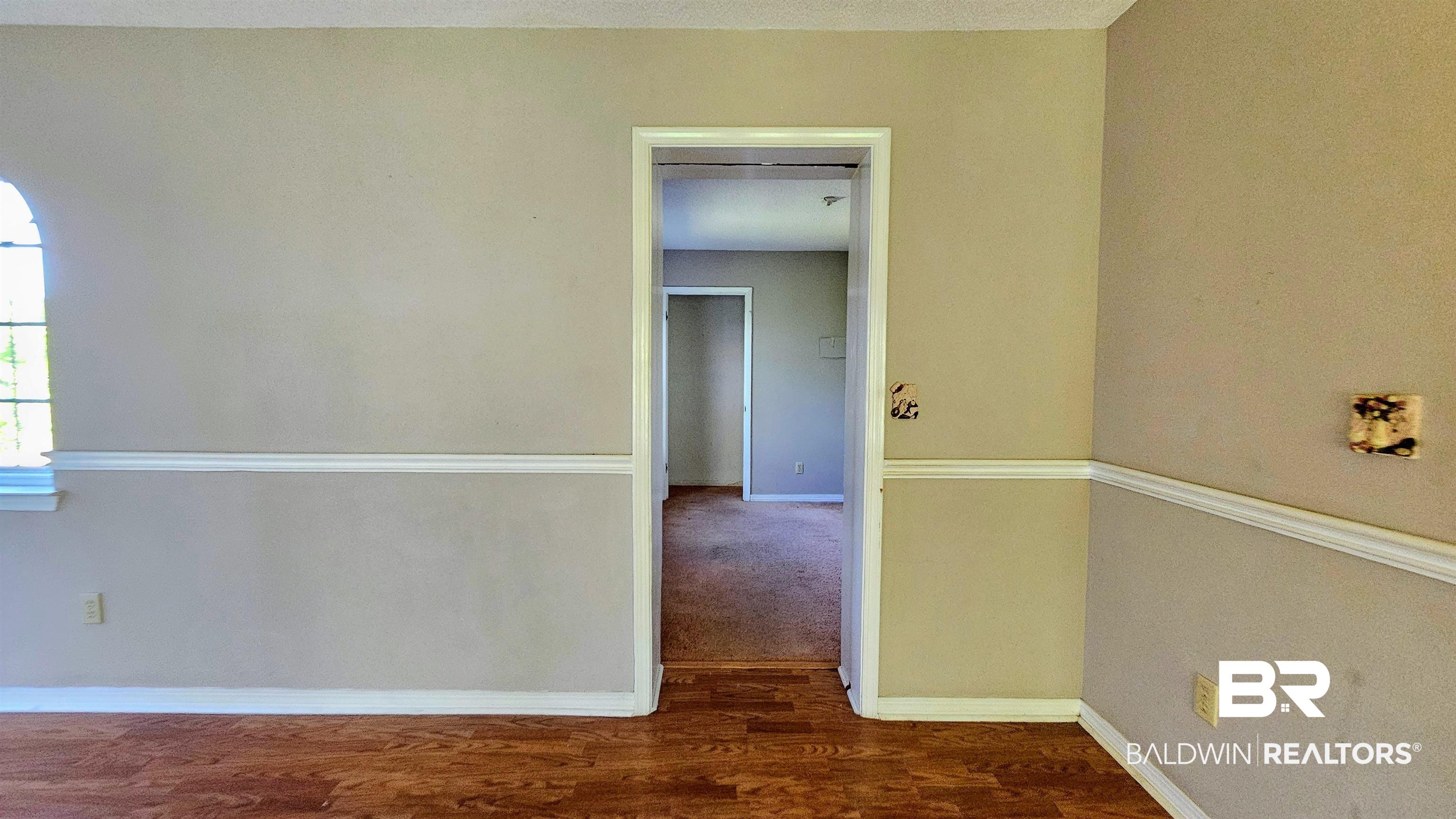 18824 Highway 41 Brewton, AL 36426 - Photo 32 of 40 Interior space featuring wood-finish flooring, light-toned walls with chair rail molding, and an arched window
