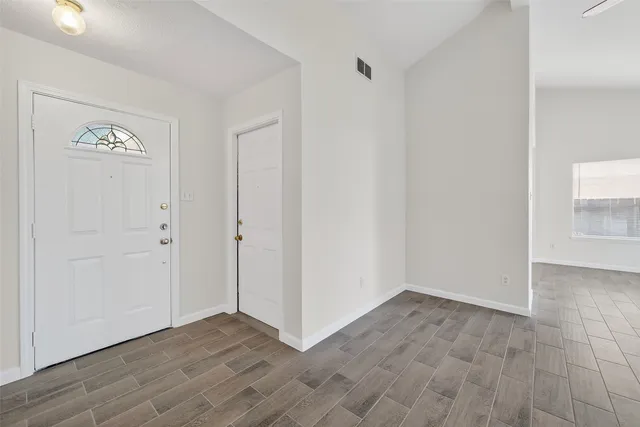 a view of an empty room with a fireplace and window