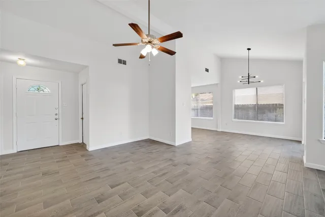 a view of an empty room with a fireplace and a window
