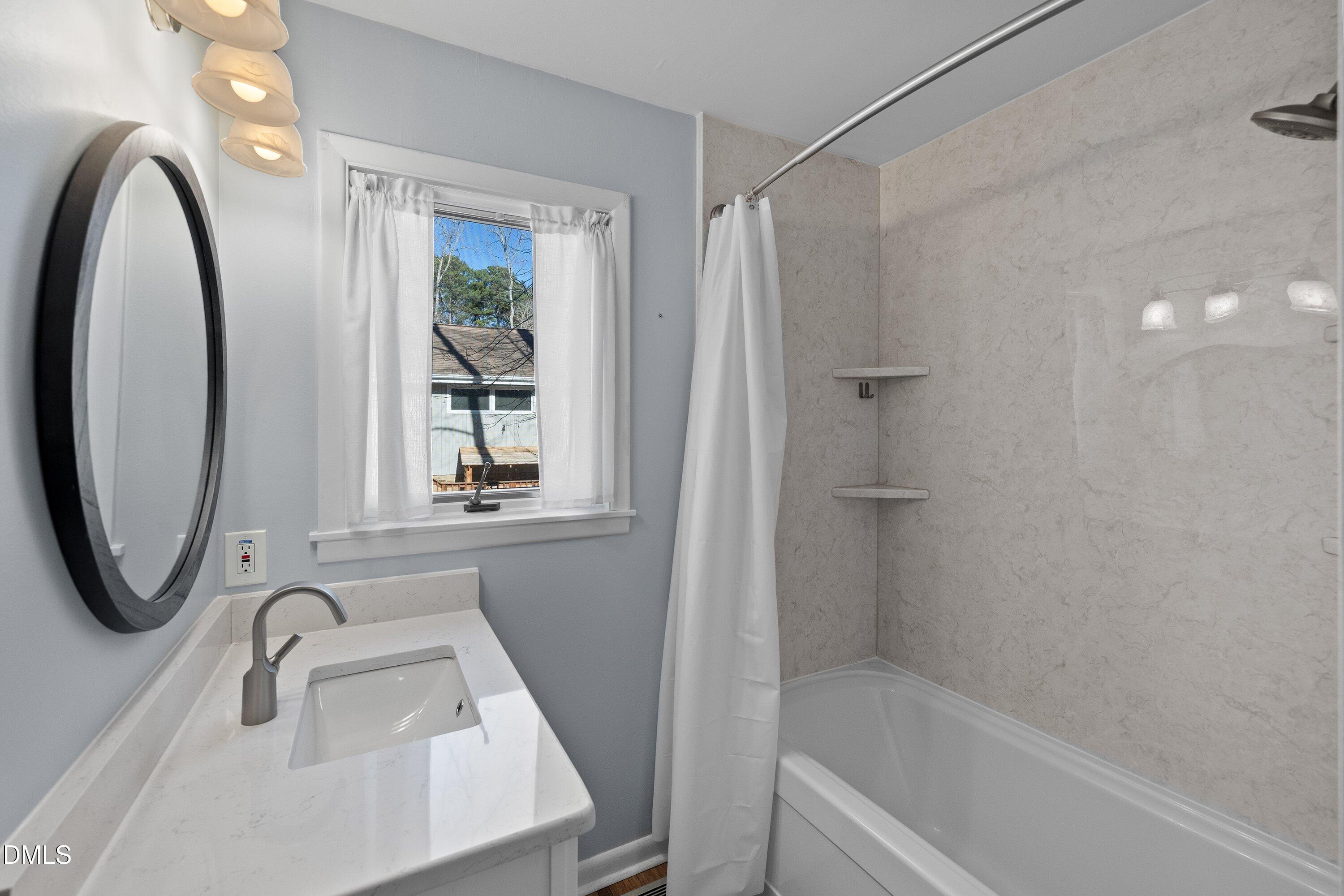 3113 Chipping Wedge Sanford, NC 27332 - Photo 14 of 42 a bathroom with a sink a bathtub and a window