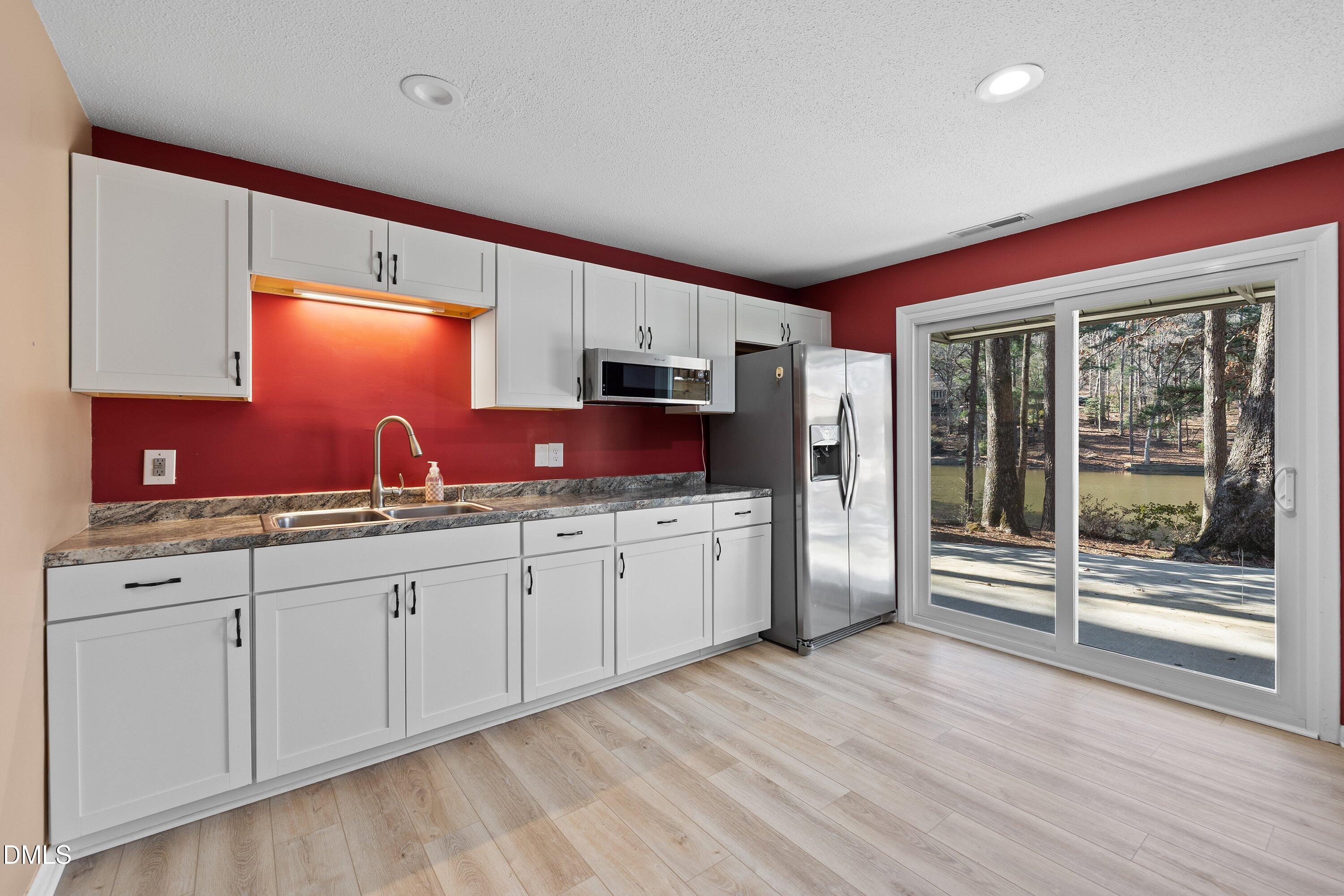3113 Chipping Wedge Sanford, NC 27332 - Photo 18 of 42 a kitchen with granite countertop a stove a sink and a refrigerator