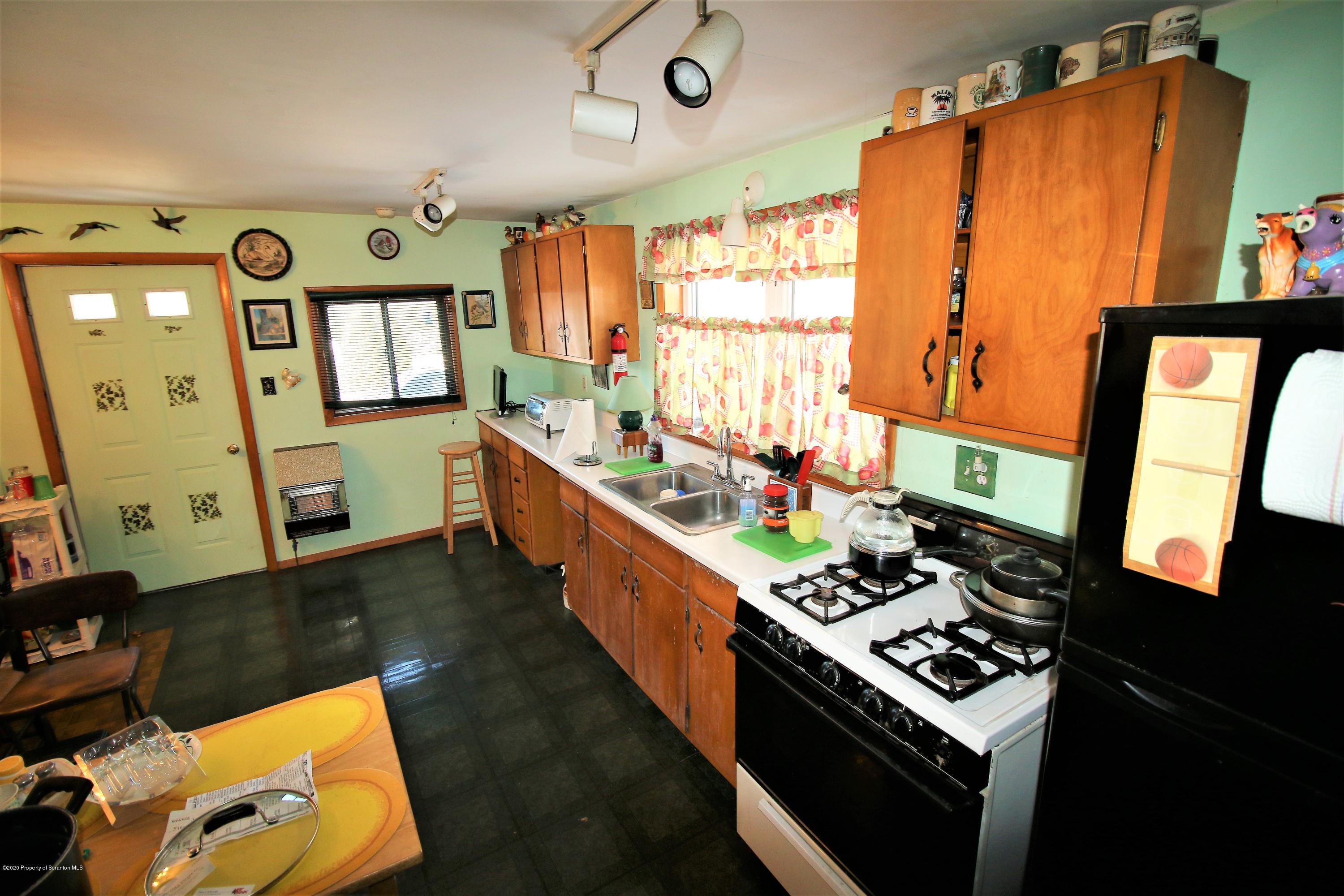 161 Spudeno Road Moscow, PA 18444 - Photo 8 of 16 a kitchen with stainless steel appliances a stove a chimney a sink and a dining table