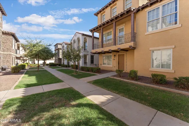 a view of a white house with a yard and plants