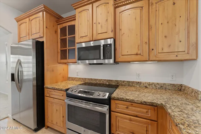 a kitchen with stainless steel appliances granite countertop a stove microwave and refrigerator