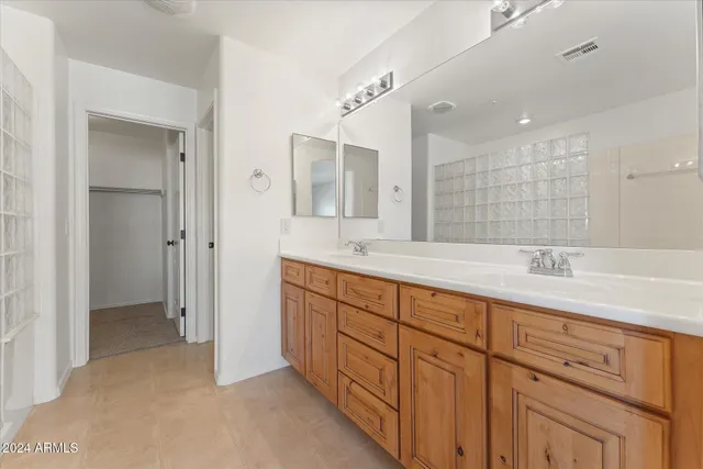 a spacious bathroom with double sink and a mirror