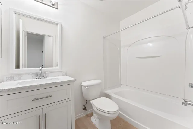 a bathroom with a granite countertop toilet a sink and a bathtub