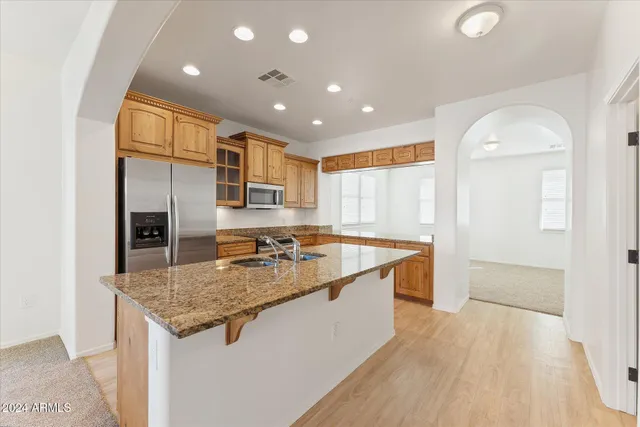 a kitchen with stainless steel appliances granite countertop a sink and a refrigerator