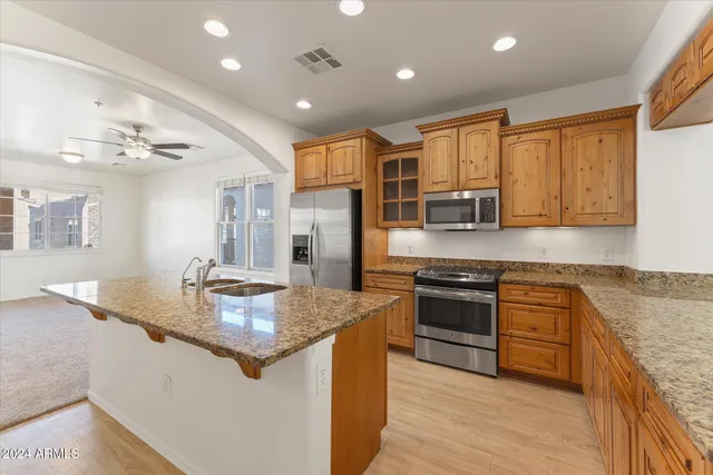 a kitchen with stainless steel appliances granite countertop a sink stove and refrigerator