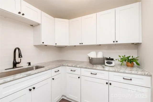 a kitchen with white cabinets and a sink