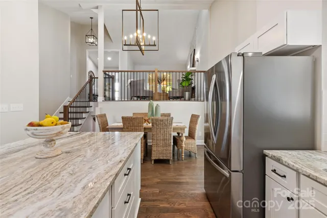 a kitchen with refrigerator and chairs