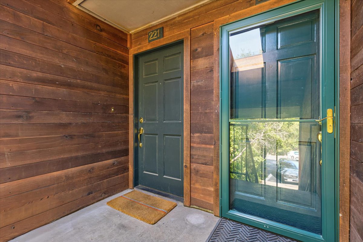 4711 Spicewood Springs Road, Unit 4222 Austin, TX 78759 - Photo 33 of 35 A welcoming entry features a paneled main door and a glass storm door, complemented by rustic wood siding.