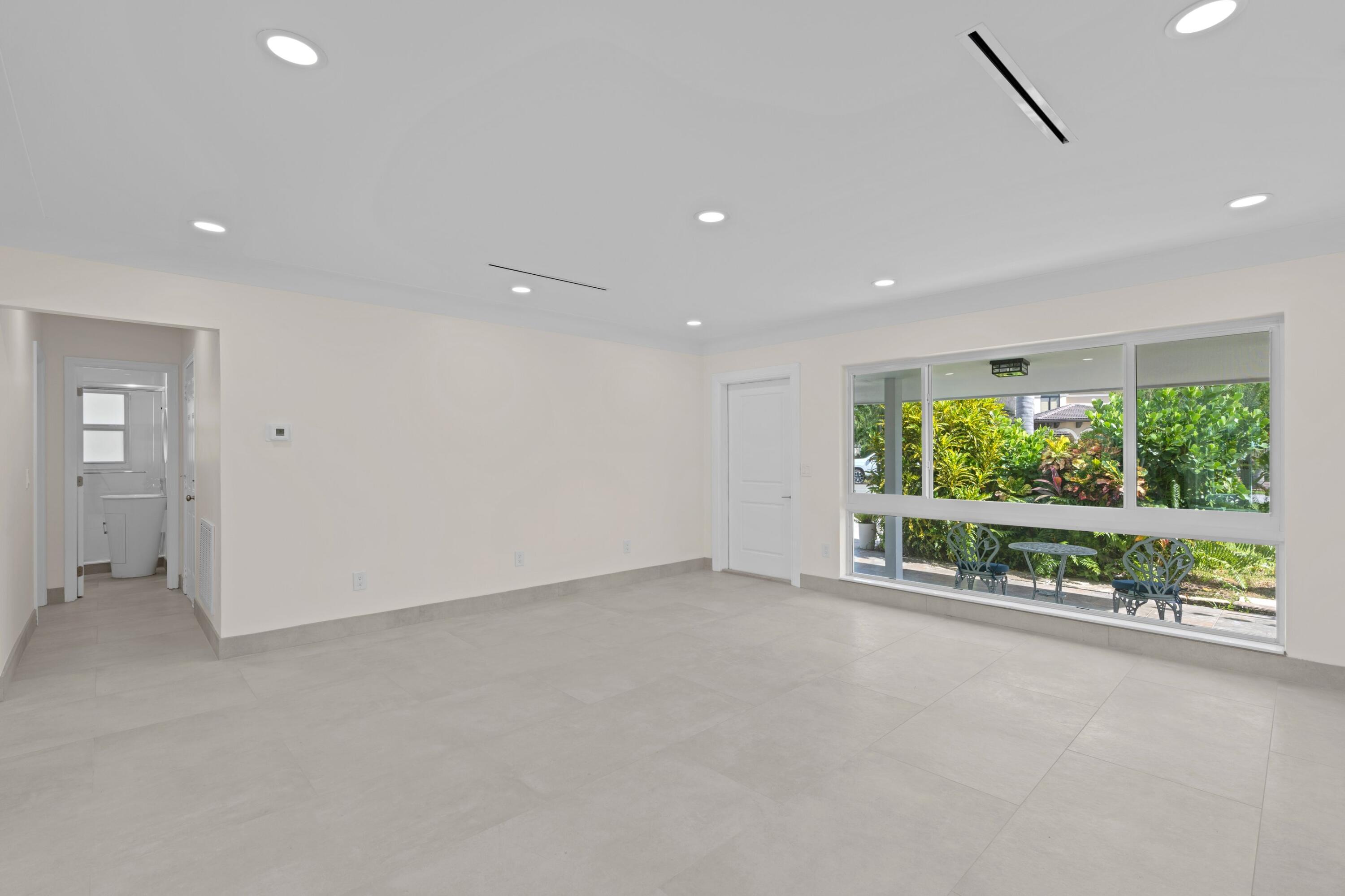 391 Southeast 7th Avenue Pompano Beach, FL 33060 - Photo 26 of 38 an empty room with wooden floor and garden view