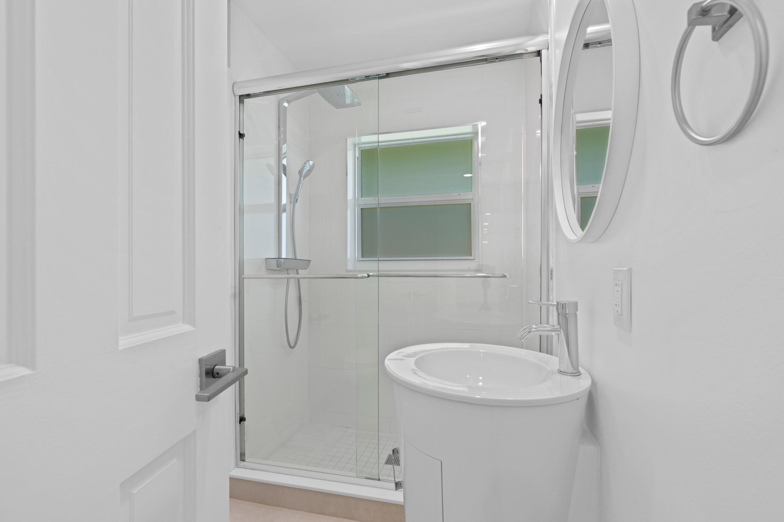 391 Southeast 7th Avenue Pompano Beach, FL 33060 - Photo 35 of 38 a bathroom with a sink a toilet and a mirror