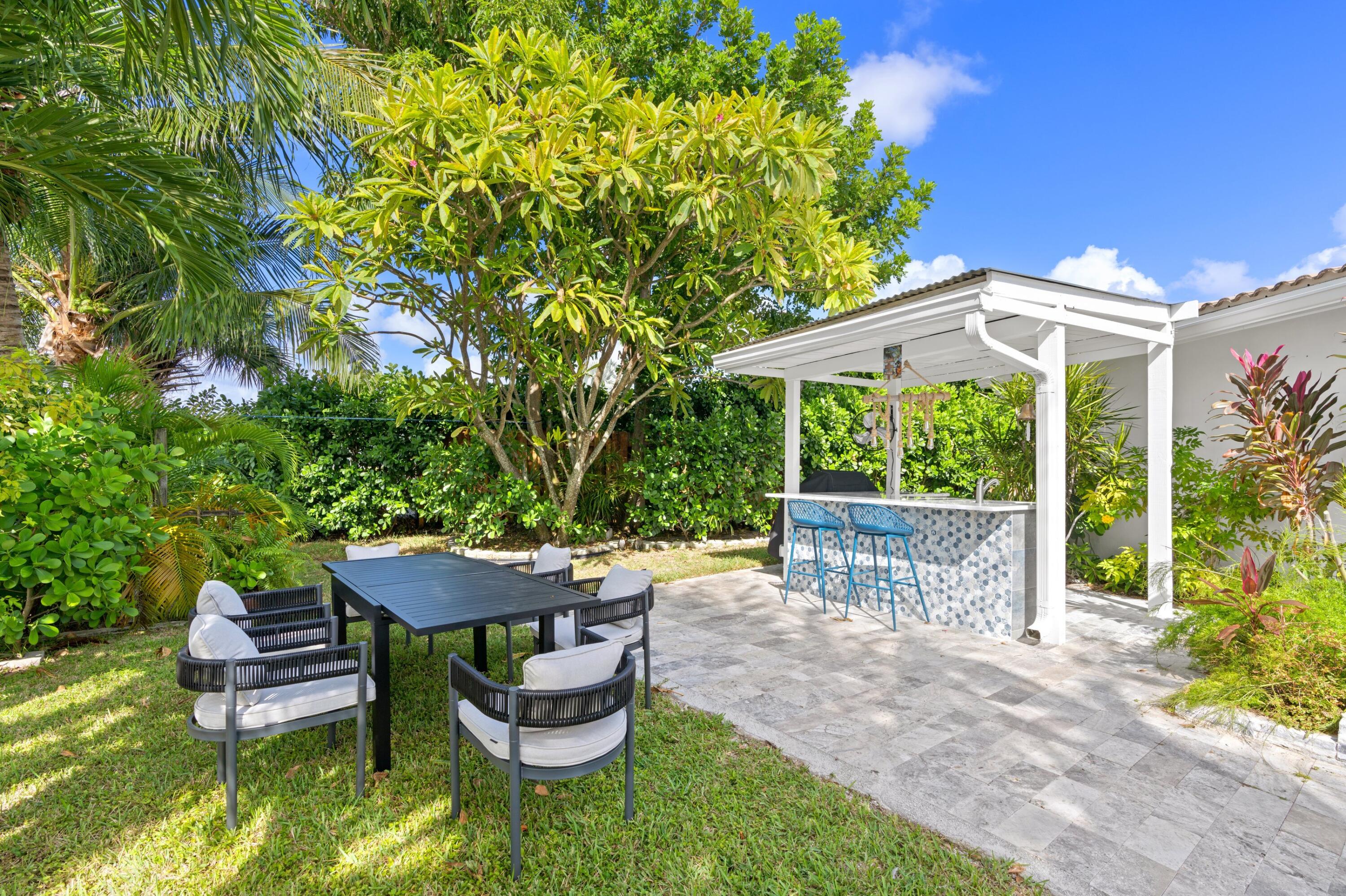 391 Southeast 7th Avenue Pompano Beach, FL 33060 - Photo 7 of 38 a view of a patio with table and chairs potted plants with large tree
