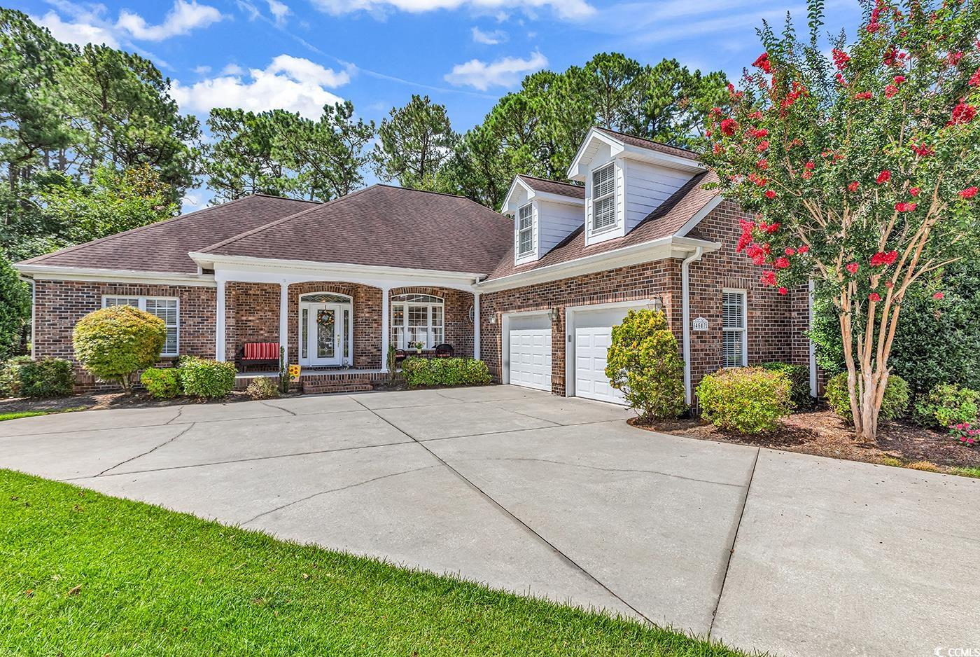 4507 Smilax Place Murrells Inlet, SC 29576 - Photo 1 of 39 View of front of home featuring brick siding, covered porch, driveway, an attached garage, and roof with shingles