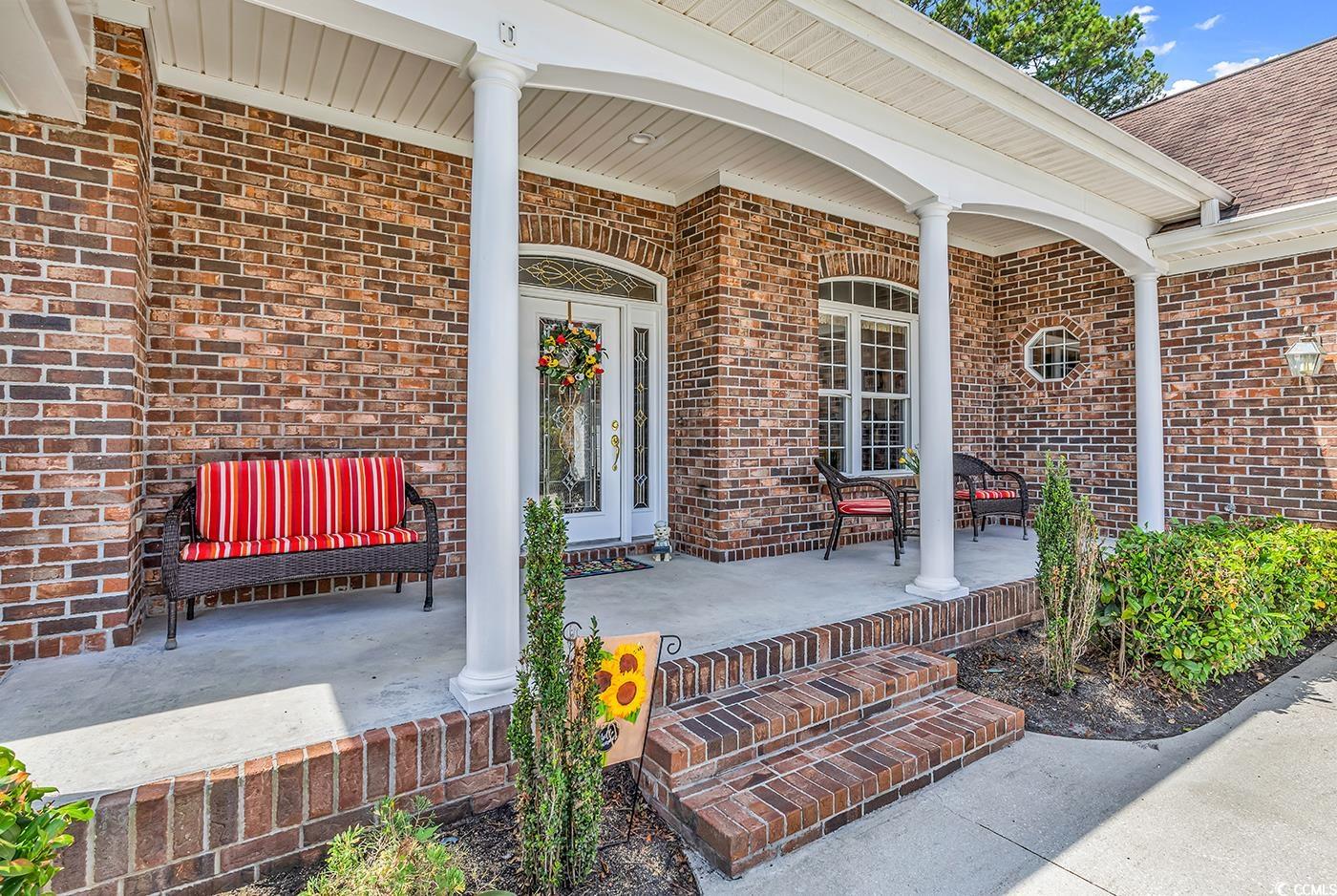 4507 Smilax Place Murrells Inlet, SC 29576 - Photo 2 of 39 Property entrance with covered porch, brick siding, and roof with shingles